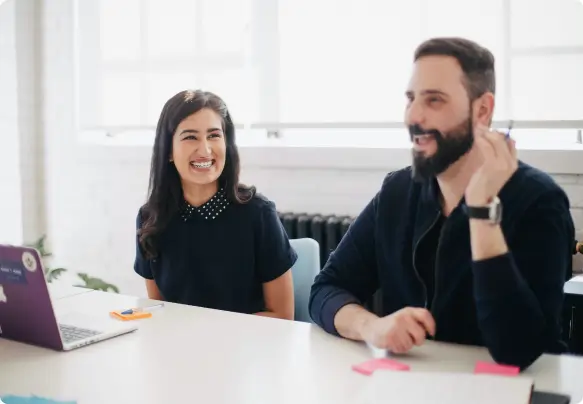 Uma mulher e um homem sorrindo em um ambiente de escritório